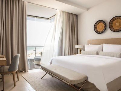 Helles Hotelzimmer mit großem Bett, Balkon und stilvollen Dekorationen an der Wand