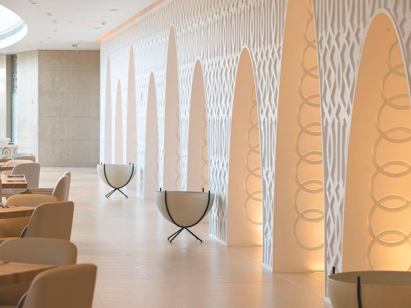 Hall d'hôtel moderne avec fauteuils confortables et niches murales éclairées décoratives.