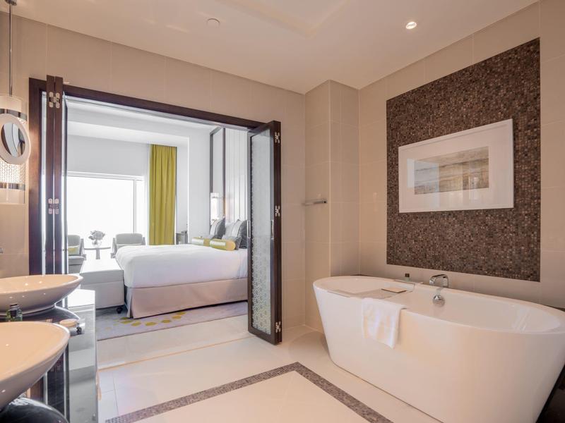 Chambre d'hôtel moderne avec baignoire indépendante et vue sur la chambre.