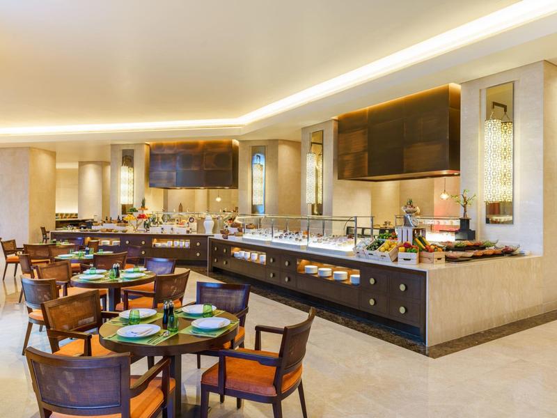 Restaurant d'hôtel moderne avec buffet et tables élégamment dressées.