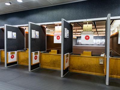 Interieur van een moderne schietbaan met schiethokken en doelborden.