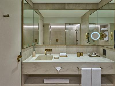 Modernes Badezimmer mit großem Doppelwaschbecken, Wandspiegeln und minimalistischer Einrichtung.