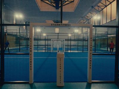 Verlichte paddle-tennisbaan in de avond met moderne voorzieningen.