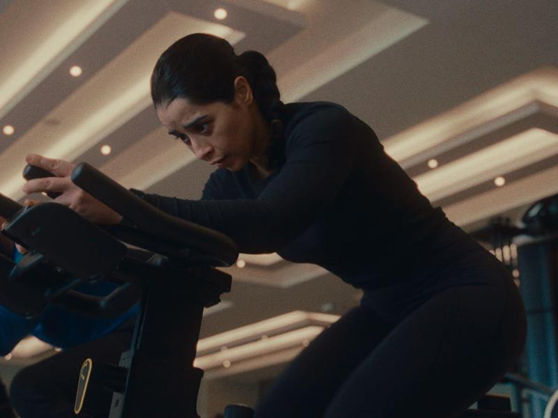 Mehrere Personen trainieren konzentriert auf Heimtrainern in einem modernen Fitnessstudio.