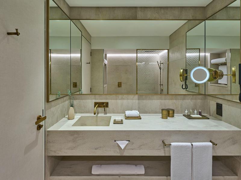 Modernes Badezimmer mit großem Doppelwaschbecken, Wandspiegeln und minimalistischer Einrichtung.