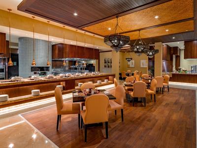 Restaurante moderno con suelos de madera, elegantes arañas y cómodas sillas en el buffet.