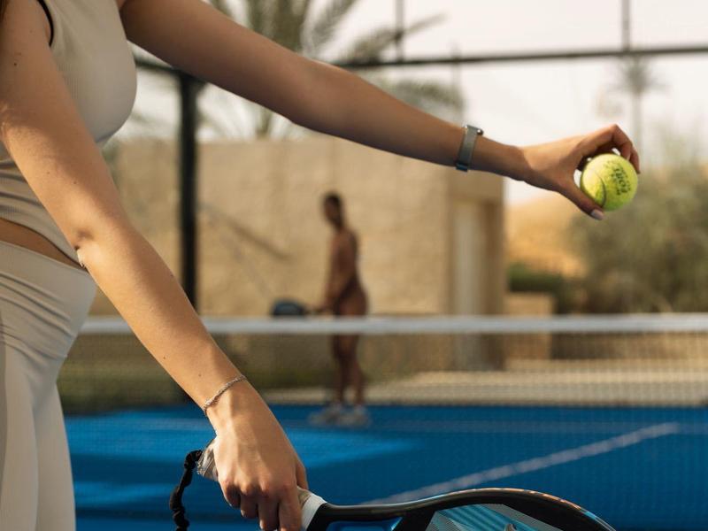 Luxury outdoor pool next to desert-facing hotel room with open doors and wooden ceiling.