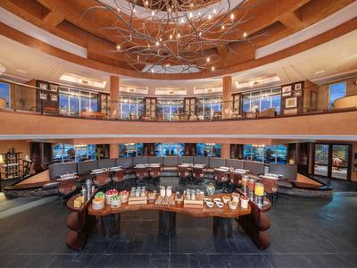 Großer, runder Verkaufsraum mit Holzdecke, heller Beleuchtung und zentraler Auslage.