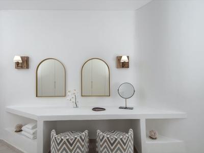 Minimalist bathroom with two round mirrors and white walls