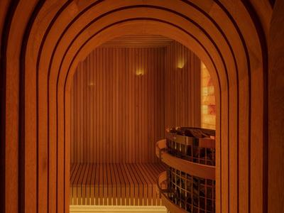 View through arched wooden frame into cozy sauna room with benches and lighting.