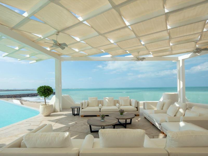 Luxury terrace with white sofas and sea view under sunshade