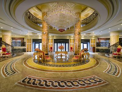 Elegante Hotellobby mit rundem Teppich, Kronleuchter und stilvoller Einrichtung.