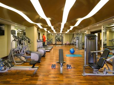 Fitnessraum mit speziellem Parkettboden und modernen Trainingsgeräten in einem Hotel.