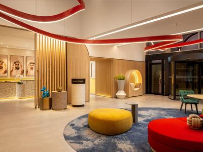 Modern eingerichtete Hotellobby mit bunten Sitzmöbeln und stilvoller Beleuchtung.