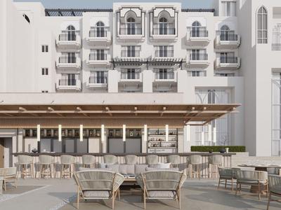 Moderner Hotelaußenbereich mit weißen Wänden, Balkonen und bequemen Sitzbereichen im Freien.