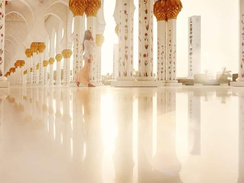 Bright, modern hotel lobby with white columns and hanging decorations.