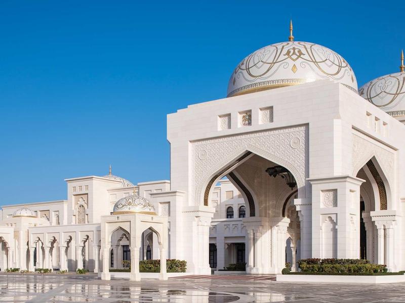 White building with domes and arches under clear blue sky