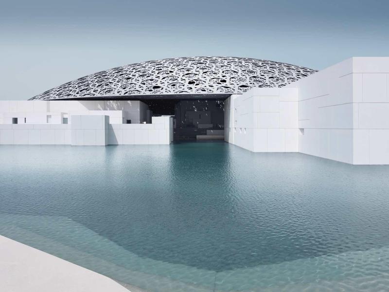 Modern white building structure with large water pool and intricate dome in the background