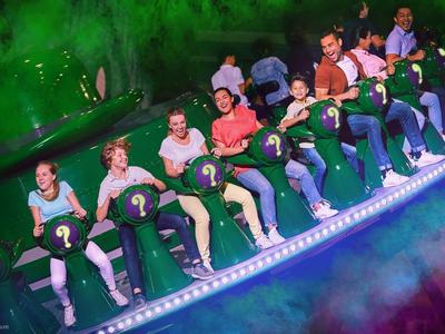 Persone su una giostra con serpenti verdi luminosi al buio