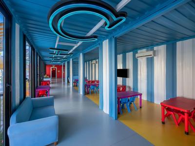 Couloir d'hôtel moderne avec mobilier coloré et murs et plafond bleus et blancs.