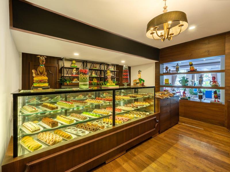Boulangerie moderne avec vitrine éclairée, sol en bois et lustre élégant.