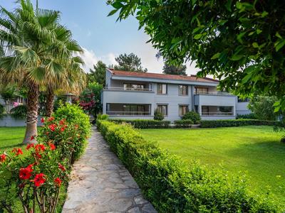 Weg durch einen gepflegten Garten zu einem modernen zweistöckigen Gebäude