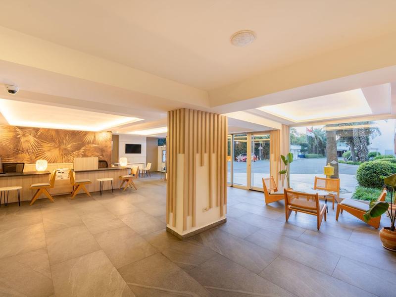 Helles, modernes Wartezimmer mit Sitzgruppen, Pflanzen und großem Fenster für viel Tageslicht.