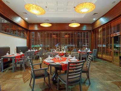 Elegantes Restaurant mit Holzmöbeln, rund gedeckten Tischen und warmem Licht.