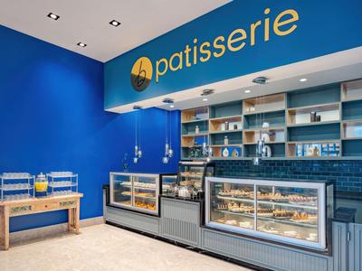 Moderne Patisserie mit blauen Wänden und mehreren Auslagen für Gebäck.