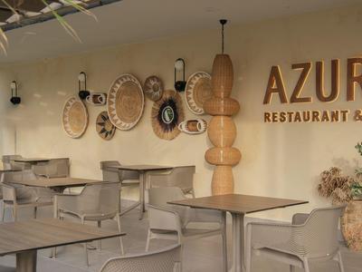 Modernes Restaurant mit Holztischen, Korbdekorationen an der Wand und Pflanzen in Töpfen.