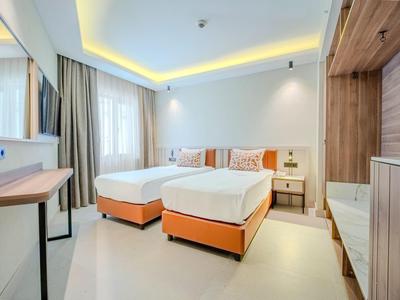 Helles Hotelzimmer mit zwei Einzelbetten und modernen Holzmöbeln