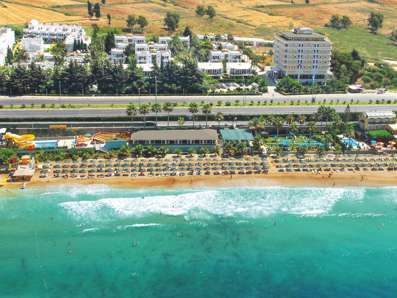 Ośrodek hotelowy z basenem i piaszczystą plażą nad turkusowym morzem na obszarze wiejskim