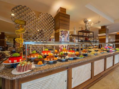 Buffet mit verschiedenen Desserts und Obst in einem Hotelrestaurant.