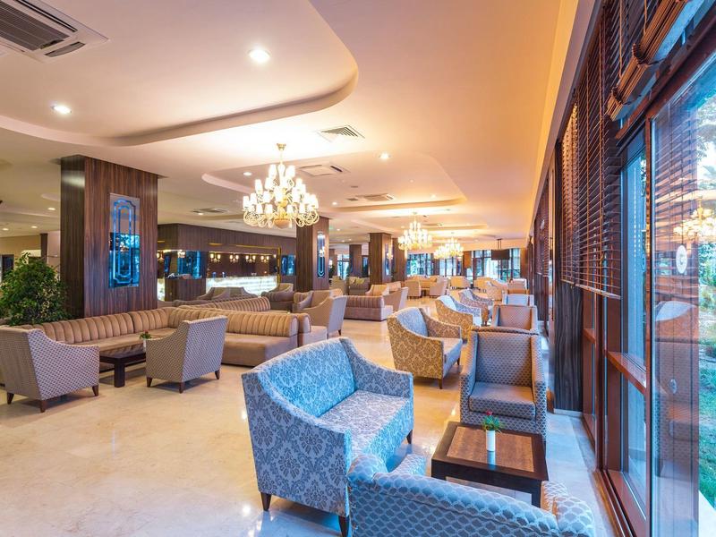 Elegante area lounge dell'hotel con comode poltrone e grandi finestre.