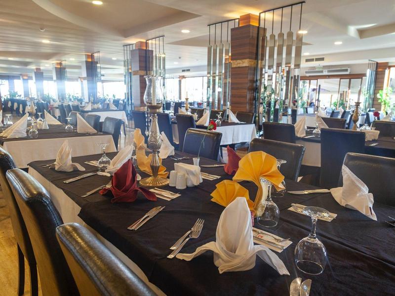 Ristorante d'hotel elegante con tavoli neri e tovaglioli piegati.