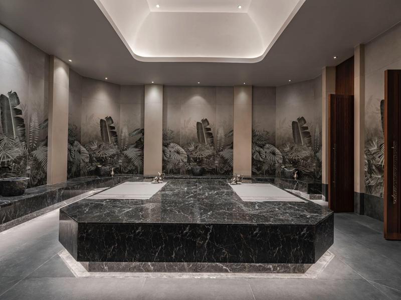 Sala de bienestar moderna con plataformas de mármol e iluminación tenue en un hotel.