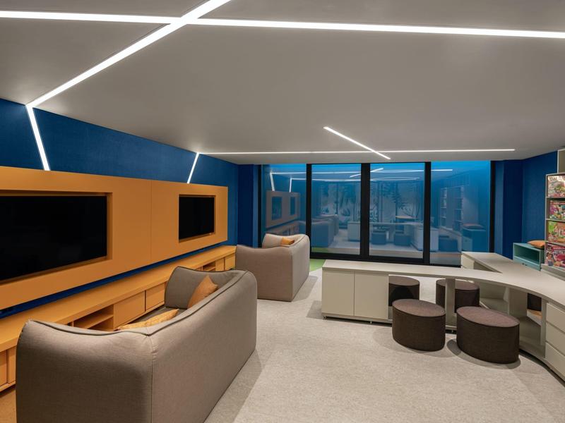 Lounge moderna con asientos cómodos y gran ventana con vista a la ciudad.