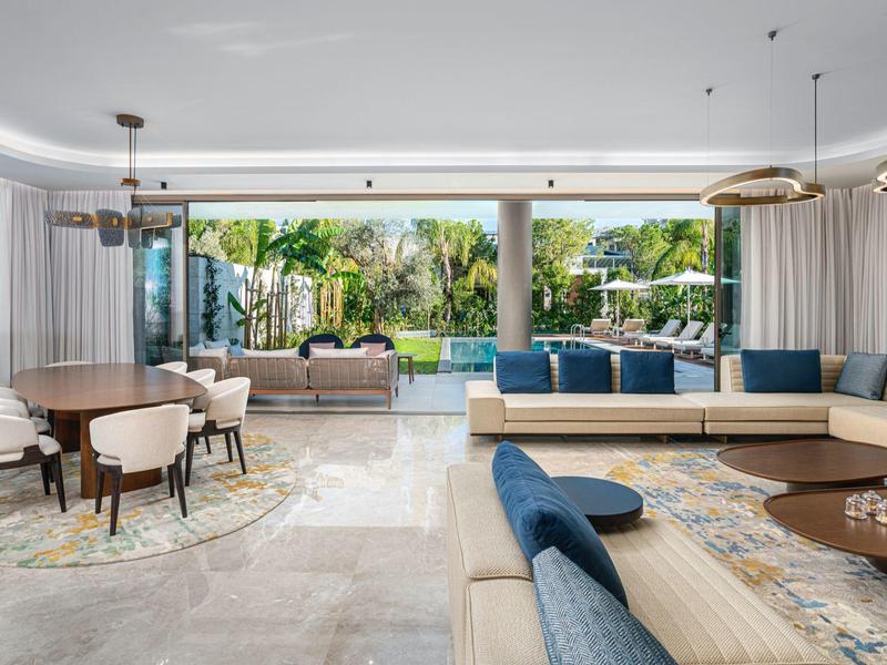 Spazio giorno moderno e aperto con grandi finestre vista piscina e giardino