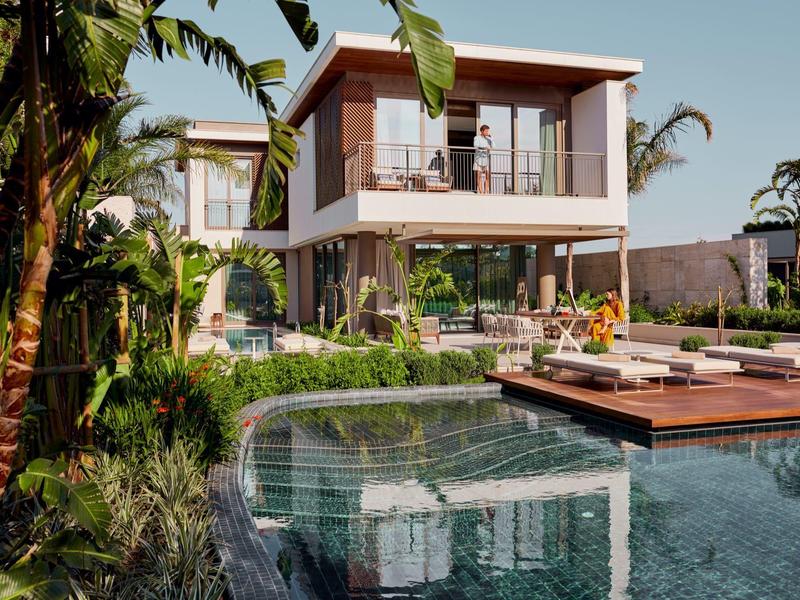 Villa moderna con terrazza, piscina e piante tropicali con tempo soleggiato