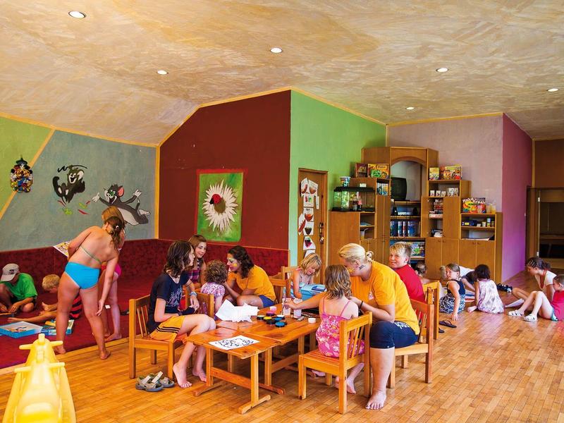 Children play and craft in a colorful, spacious hotel playroom.