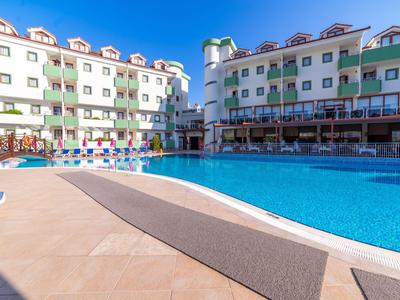 Großes Hotel mit Pool und Terrasse bei sonnigem Himmel.