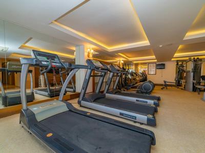 Fitnessraum mit mehreren Laufbändern und Kraftgeräten in einem Hotel.