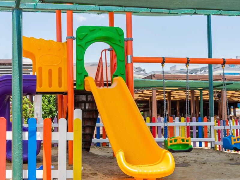 Scivolo colorato e recinzione sotto una copertura vicino a una località balneare.