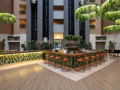 Moderní hotelový bar s botanickou dekorací a stylovým sezením.