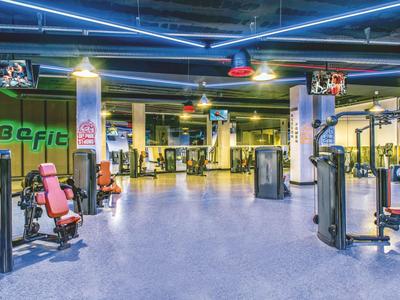 Jasna siłownia z różnymi urządzeniami do ćwiczeń i nowoczesnym oświetleniem