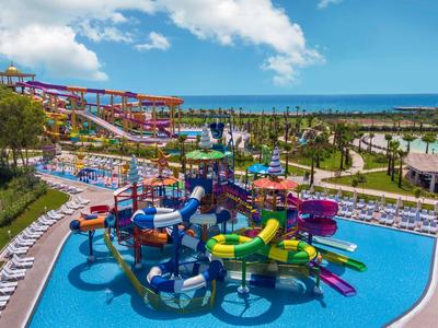 Scivoli d'acqua colorati e piscine in un grande parco acquatico all'aperto vicino al mare.