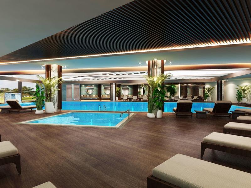 Area piscina interna moderna con pavimento in legno e lettini in un hotel di lusso.