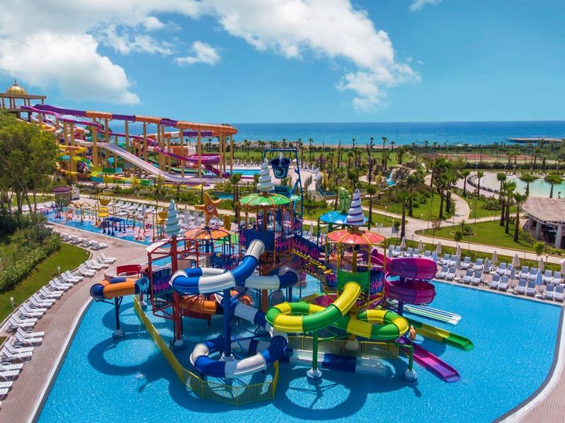 Scivoli d'acqua colorati e piscine in un grande parco acquatico all'aperto vicino al mare.