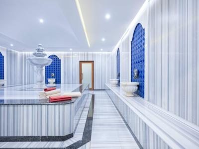 Eleganter Dampfbadraum mit Marmor, blauen Nischen und Wasserbrunnen, modern beleuchtet.