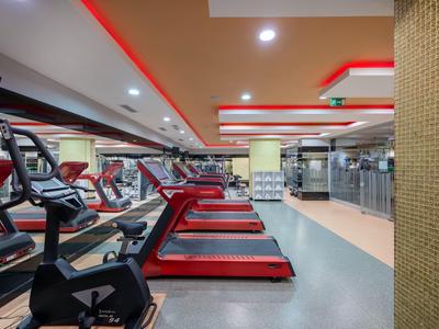 Moderne Fitnessstudio mit Laufbändern und kräftigem Beleuchtungssystem.